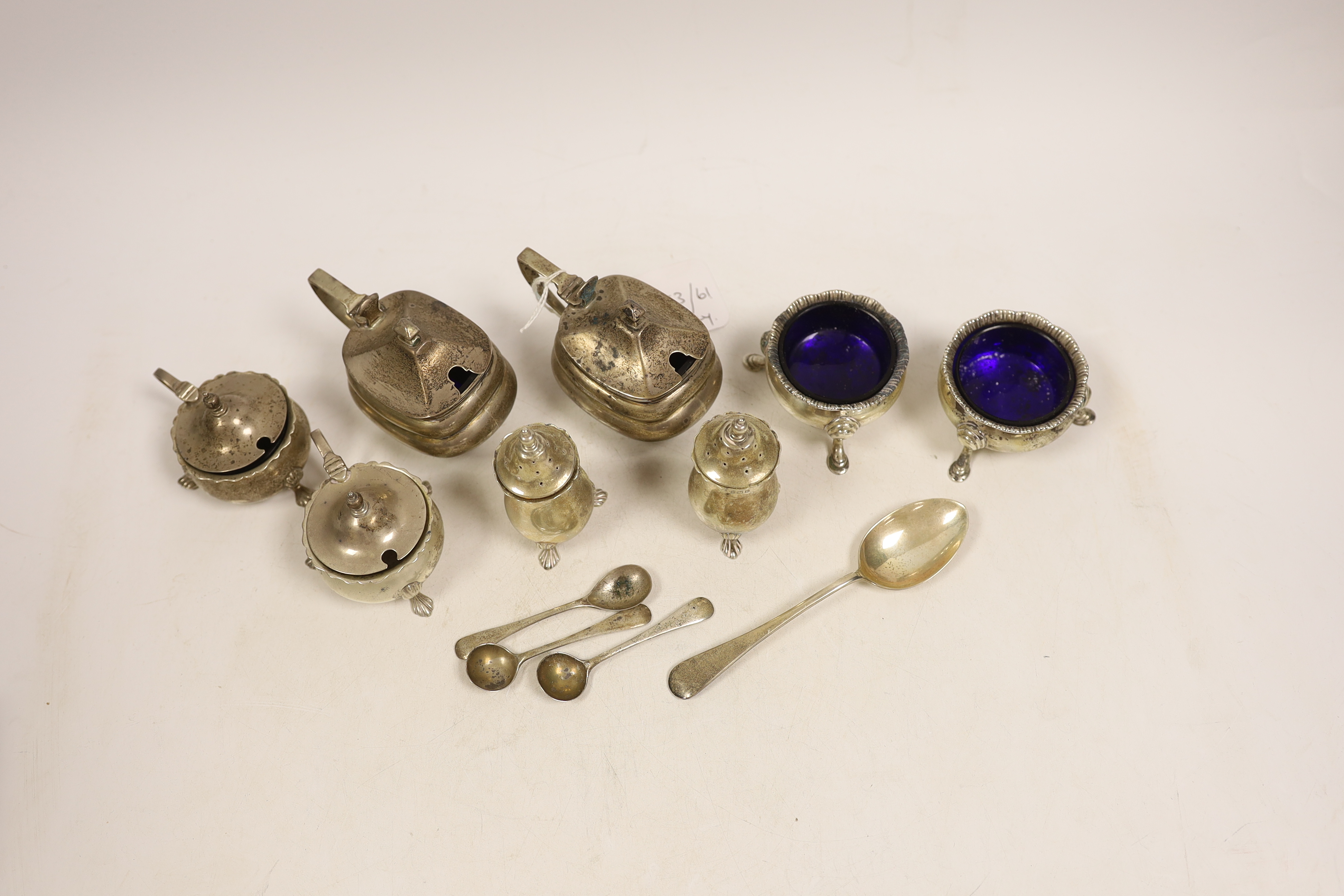 A pair of George V oblong silver lidded mustards with blue glass liners, two other mustards, a pair of peppers, a pair of 'cauldron' salts, three condiment spoons and a teaspoon.